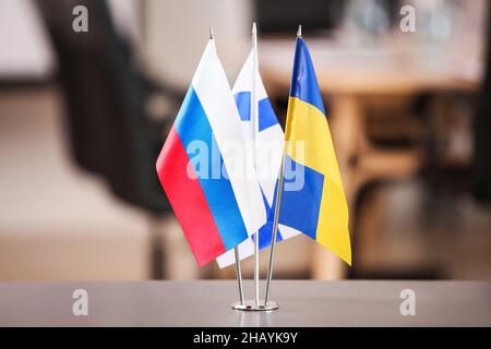 Flaggen von Russland, Schweden und Finnland auf dem Tisch im Konferenzraum Stockfoto