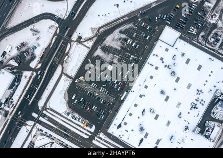 Luftaufnahme des Supermarktparkplatzes mit geparkten Autos in der Wintersaison Stockfoto