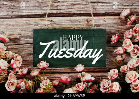 Happy Tuesday Typografie Text mit rosa Blumen Bouquet auf Holz Hintergrund Stockfoto