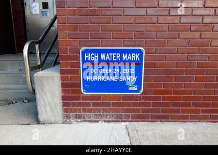 „High Water Mark“-Schilder zur Erinnerung an den höchsten Punkt der Überschwemmungen an diesem bestimmten Ort während des Hurrikan Sandy, New York, NY. Stockfoto