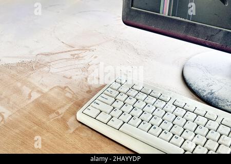 Alte Tastatur und kaputter Monitor stehen auf einem Holztisch und sind in der Nähe einer Werkstatt mit dickem Staub bedeckt Stockfoto