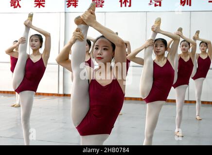 Handan, Handan, China. 16th Dez 2021. Am 16. Dezember übten Kunstbewerber im Übungsraum eines Tanztrainingszentrums in der Stadt Handan, Provinz Hebei, grundlegende Fähigkeiten aus.als sich die Kunstprüfung 2022 in einem Tanztrainingszentrum in der Stadt Handan, Provinz Hebei, näherte, Drei ältere Studenten, die sich für das Kunsttanz-Major bewerben, verstärken die intensive Ausbildung von professionellen Kursen, um für die bevorstehende Kunstprüfung zu schwitzen, um ihre Träume zu verwirklichen. (Bild: © SIPA Asia via ZUMA Press Wire) Stockfoto