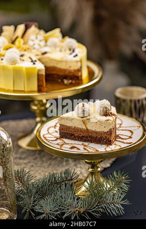 Ein Stück köstlicher, dreilagiger Schokoladenmousse-Torte, verziert mit Kokosnusskugel Stockfoto