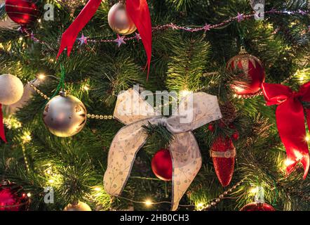 Nahaufnahme des Weihnachtsbaums mit Girlanden und Dekorationen. Seitenansicht. Weihnachten Hintergrund. Stockfoto