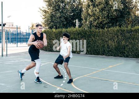 Zwei kaukasische Männer spielen Basketball in einem städtischen Gericht Stockfoto