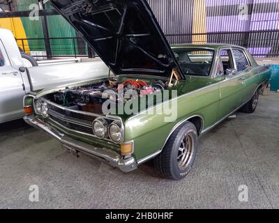 AVELLANEDA, ARGENTINIEN - 06. Dez 2021: Eine luxuriöse grüne Ford Fairlane 1970s Limousine. Sportlicher und stilvoller Oldtimer aus Argentinien. Haube offen. Motor. Stockfoto