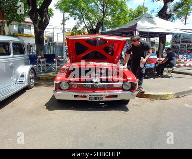 BUENOS AIRES, ARGENTINIEN - 08. Nov 2021: Mann poliert einen roten, sportlichen Chevrolet Chevy SS Coupé 1970s von GM Argentina. Haube öffnen. Motor. Vorderansicht. Expo Stockfoto