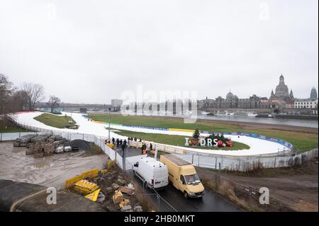 Dresden, Deutschland. 16th Dez 2021. Pistenarbeiter bereiten vor dem Hintergrund der Altstadt einen zukünftigen Wettkampfkurs mit Kunstschnee am Elbufer vor. Am 18. Und 19. Dezember 2021 findet in Dresden der FIS Skilanglauf-Sprint-Weltcup statt. Quelle: Sebastian Kahnert/dpa-Zentralbild/dpa/Alamy Live News Stockfoto