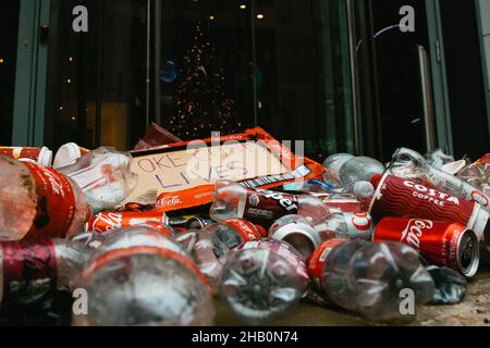 London, Großbritannien. 15th. Dezember 2021. Coca-Cola-Dosen und Plastikflaschen, die von Klimaaktivisten von Extinction Rebellion vor dem Hauptsitz von Coca-Cola EuroPacific Partners plc deponiert wurden. Die Aktivisten protestierten gegen die Rolle des Unternehmens als weltweit größter Kunststoffverschmutzer und einige seiner Geschäftspraktiken. Kredit: Mark Kerrison/Alamy Live Nachrichten Stockfoto