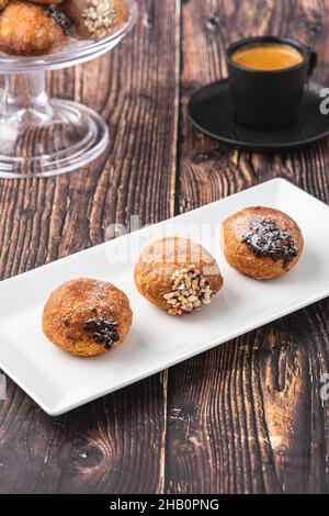 Bombolon oder Bomboloni ist ein italienisches gefülltes Donut- und Snackfutter. Deutsche Krapfen - Krapfen oder berliner - gefüllt mit Marmelade und Schokolade Stockfoto