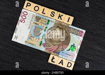 Der Satz 'Polski Ład' wurde übersetzt als 'Polnischer Orden' und eine polnische 500 PLN Banknote auf grauem Hintergrund. Neue Steuervorschriften in Polen. Foto ta Stockfoto
