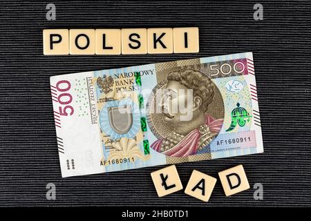 Der Satz 'Polski Ład' wurde übersetzt als 'Polnischer Orden' und eine polnische 500 PLN Banknote auf grauem Hintergrund. Neue Steuervorschriften in Polen. Foto ta Stockfoto