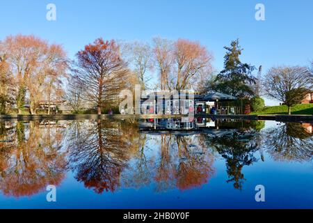 Woodbridge, Suffolk, Großbritannien - 16. Dezember 2021: The Tea Hut, ein Café am Fluss Deben. Das Gebäude spiegelt sich an einem hellen Wintermorgen im Bootsteich wider. Stockfoto