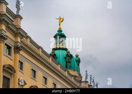 Schöne Nahaufnahme der vergoldeten Fortuna-Figur, die an einem bewölkten Tag in der Kuppel des berühmten Schlosses Charlottenburg als Windfahne dient... Stockfoto