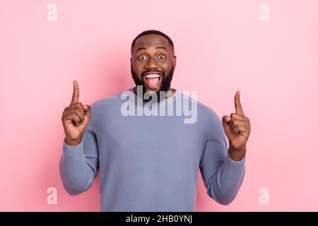 Foto von verrückt überrascht Mann zeigen Zeigefinger leeren Raum tragen graues Hemd isoliert rosa Farbe Hintergrund Stockfoto