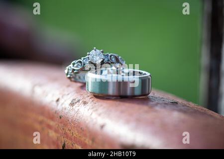 Hochzeitsringe aus Weißgold außen auf verrosttem Kupfermetall Stockfoto