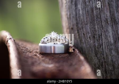 Hochzeitsringe aus Weißgold außen auf verrosttem Kupfermetall Stockfoto