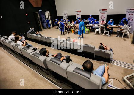Pasay City, Philippinen. 16th Dez 2021. In einem Kino, das in einem Einkaufszentrum in Pasay City, Philippinen, am 16. Dezember 2021 in einen Impfbereich verwandelt wurde, warten die Menschen darauf, mit COVID-19-Impfstoff geimpft zu werden. Die Philippinen haben die ersten beiden bestätigten Fälle der Omicron-Variante bei zwei Reisenden aus Nigeria bzw. Japan registriert, teilte das Gesundheitsministerium (DOH) am Mittwoch mit. Quelle: Rouelle Umali/Xinhua/Alamy Live News Stockfoto
