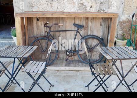 Vintage Bike als coole Dekoration im Outdoor Sitzbereich des Restaurants in Marzamemi, Sizilien, Italien. Stockfoto