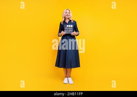 Foto von charmanten glänzenden Dame Rentner gekleidet Denim Outfit mit Klappbrett isoliert gelbe Farbe Hintergrund Stockfoto