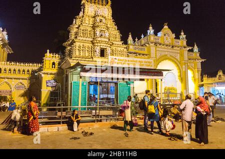 Mysore, Karnataka, Indien : die Menschen stehen nachts vor dem Tempel am Balarama Nordtor des beleuchteten Mysore Maharaja Palastes. Stockfoto