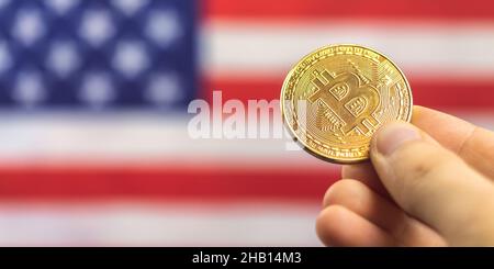 Hand mit Bitcoin und USA Flagge auf Hintergrund, Banner. Kryptowährung und Konzept der Vereinigten Staaten von Amerika Stockfoto