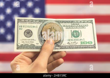 Hand mit Bitcoin mit Dollar auf USA Flagge Hintergrund. Kryptowährung und Konzeptfoto der Vereinigten Staaten von Amerika Stockfoto