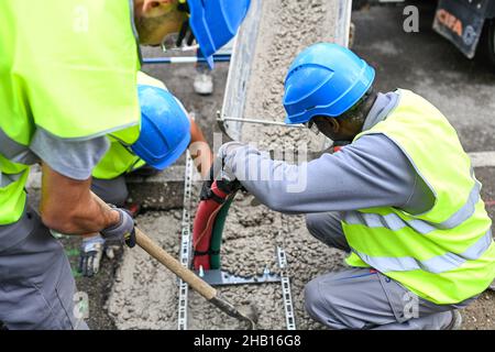 Bron, am 2021/07/08 (Zentralfrankreich): Erste kohlenstoffarme städtische Baustelle mit einem vollelektrischen Kompaktbagger und einem Hybrid-Lkw-Mix Stockfoto