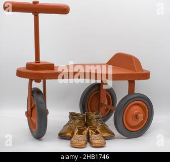 Stillleben der Ehemänner des Fotografen handgefertigte Dreirad von seinem Vater mit dem Fotografen und Ehemann Bronze Baby Schuhe. Stockfoto