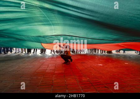 Savar, Bangladesch. 16th Dez 2021. Die Menschen winken Nationalflaggen, während sie sich versammeln, um am nationalen Denkmal der Märtyrer des Unabhängigkeitskrieges 1971 ihren Respekt zu zollen, um den Tag des Sieges 50th zu feiern, der das Ende eines bitteren neunmonatigen Unabhängigkeitskrieges von Pakistan am 16. Dezember 2021 in Savar markiert. Bangladesch feiert den 50th. Jahrestag seines nationalen Sieges und erinnert sich an die tapferen Freiheitskämpfer, die gekämpft und das ultimative Opfer gebracht haben, um das Land von den pakistanischen Truppen zu befreien. Menschen aus allen Gesellschaftsschichten versammelten sich am National Memorial von morgens an auf T Stockfoto