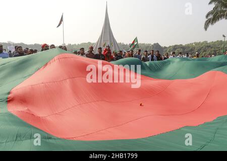 Savar, Bangladesch. 16th Dez 2021. Die Menschen winken Nationalflaggen, während sie sich versammeln, um am nationalen Denkmal der Märtyrer des Unabhängigkeitskrieges 1971 ihren Respekt zu zollen, um den Tag des Sieges 50th zu feiern, der das Ende eines bitteren neunmonatigen Unabhängigkeitskrieges von Pakistan am 16. Dezember 2021 in Savar markiert. Bangladesch feiert den 50th. Jahrestag seines nationalen Sieges und erinnert sich an die tapferen Freiheitskämpfer, die gekämpft und das ultimative Opfer gebracht haben, um das Land von den pakistanischen Truppen zu befreien. Menschen aus allen Gesellschaftsschichten versammelten sich am National Memorial von morgens an auf T Stockfoto