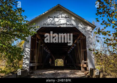 Die Cox Ford Covered Bridge überquert den Sugar Creek während des Herbstblattfarbwechsels in der Nähe von Bloomingdale in Parke County, Indiana. Stockfoto