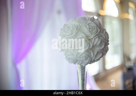 Künstliche weiße Blumenkugeln mit Diamanten in Glasvase bei der Feier des Hochzeitsempfangs Stockfoto