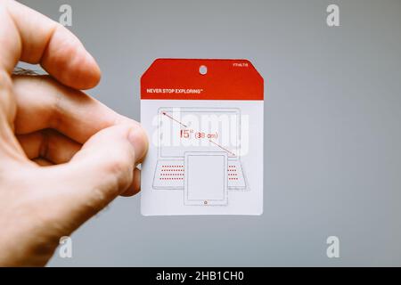 POV männliche Hand hält Etikettaufkleber der North Face Papierdokumente Stockfoto