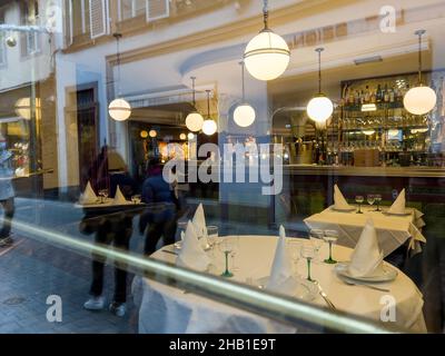Spaziergang vor dem Flo Restaurant mit Blick auf das Innere durch das Glasfenster Stockfoto