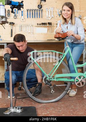 Couple pumpt die Räder auf dem Fahrrad Stockfoto