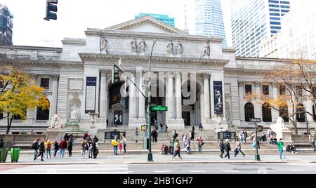 New York City, New York, USA - 21. November 2021: Blick auf das Gebäude der New York Public Library und Stufen mit Menschen, die über die 5th Avenue in Ne gehen Stockfoto
