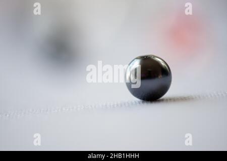 Ein isolierter schwarzer Marmor auf weißem Bokeh-Hintergrund Stockfoto