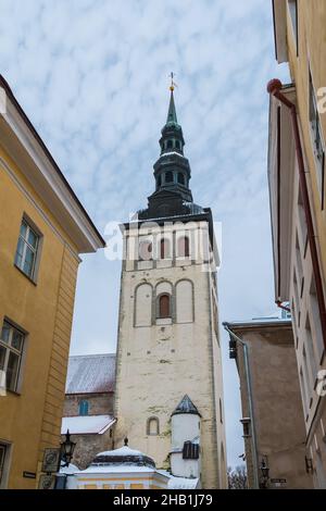 Blick aus der Nähe auf die Wohngebäude und den Turm der Nikolaikirche am bewölkten Wintertag, Altstadt von Tallinn, Estland Stockfoto