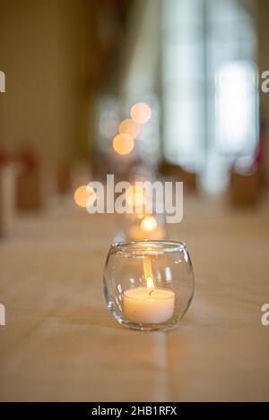 Runder Kerzenhalter aus Glas mit brennbarer Kerze auf luxuriösem Dinner-Tisch-Setting Stockfoto