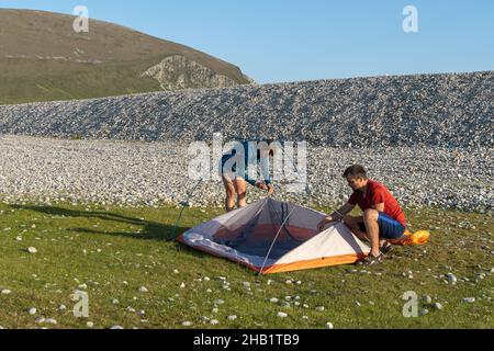 Camping Menschen Outdoor Lifestyle Paar ein Zelt in der Natur felsigen Strand aufzustellen. Stockfoto