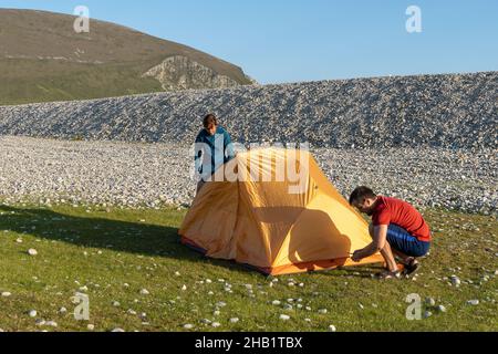 Camping Menschen Outdoor Lifestyle Paar ein Zelt in der Natur felsigen Strand aufzustellen. Stockfoto