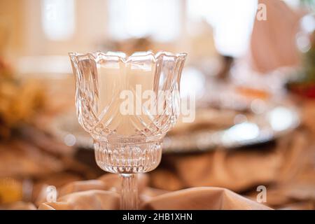 Dekorativer Kerzenhalter aus Glas im Mittelpunkt auf dem Tisch beim Hochzeitsempfang Stockfoto