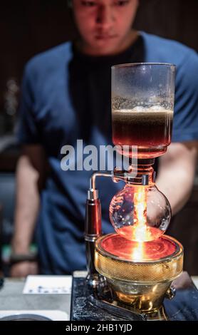 Der Barista verwendet eine Kaffeemaschine für Siphon im Hipster-Café in Bangkok Stockfoto