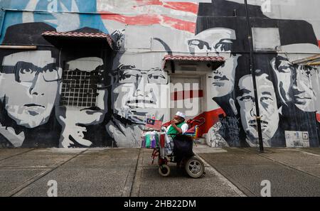 Kuala Lumpur, Malaysia. 16th Dez 2021. Ein behinderter Straßenhändler im Rollstuhl sah, wie er an einem Wandgemälde in Kuala Lumpur vorbeiritt. (Foto von Wong Fok Loy/SOPA Images/Sipa USA) Quelle: SIPA USA/Alamy Live News Stockfoto