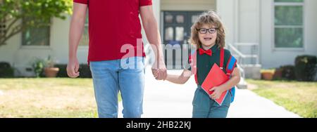 Vater unterstützt und motiviert Sohn. Kind geht zur Grundschule. Stockfoto