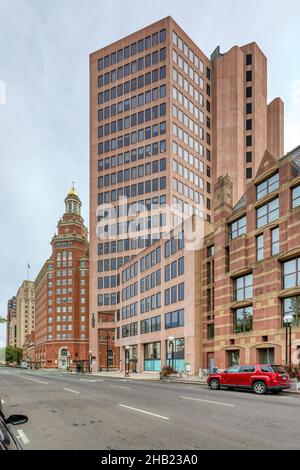 Das New Haven Savings Bank Building, ein rosafarbener Kalkstein-Wolkenkratzer, bildet einen starken Kontrast zum benachbarten Rathaus am östlichen Rand von New Haven Green. Stockfoto