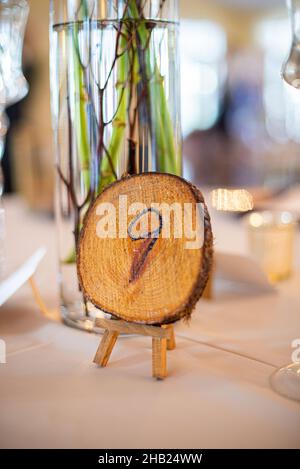 Holzstumpf mit der Nummer neun auf dem Tisch eingraviert Tischstandsanzeiger am Hochzeitstisch Stockfoto