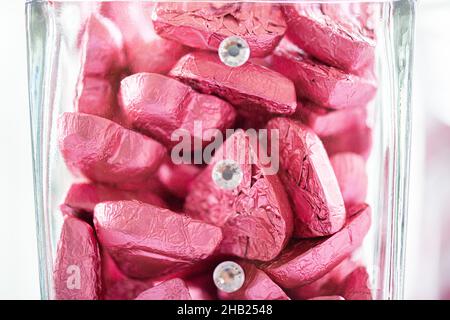 Herzförmige Schokoladen-Bonbons in rosa Aluminiumfolie an der Dessertbar eingewickelt Stockfoto