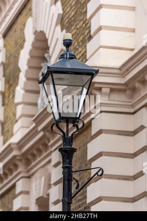 Altmodische, viktorianische Straßenlampe mit Gas- oder Kerzenantrieb, Licht auf einer Straße im historischen Stil, viktorianische gusseiserne Lampe im Vintage-Stil. Stockfoto